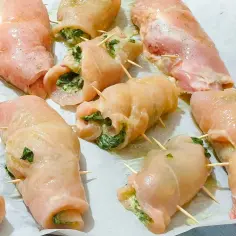 Soczyste roladki z kurczaka z piekarnika, nadziewane szpinakiem i serem, gotowe do pieczenia.