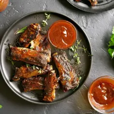 Pyszne, tradycyjne żeberka pieczone w piekarniku, polane sosem BBQ. Idealne na rodzinny obiad.