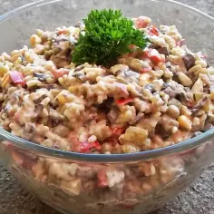 Pyszna sałatka z pieczarkami smażonymi, papryką i kukurydzą, udekorowana natką pietruszki.