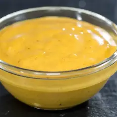 Gęsty, kremowy sos curry w szklanej miseczce, gotowy do podania z ulubionymi daniami.