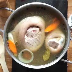 Ania gotuje golonka gotowana w bulionie z warzywami i przyprawami.