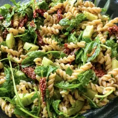 Pyszna, najlepsza sałatka z makaronem fusilli, świeżym ogórkiem, rukolą i suszonymi pomidorami.