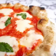 Pyszna margarita pizza z rozpływającym się serem mozzarella, sosem pomidorowym i świeżą bazylią. Idealna na szybki lunch.