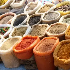 Kolorowe przyprawy do mięs w workach: papryka, kurkuma, mielone ziarna i inne aromatyczne mieszanki.