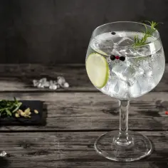 Idealne proporcje gin z tonikiem: schłodzony gin, tonik, lód, plaster limonki, rozmaryn i pieprz.