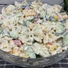 Pyszna sałatka z makaronem farfalle, ogórkiem, kukurydzą i papryką, polana kremowym sosem. Idealna sałatka z makaronem na szybko!