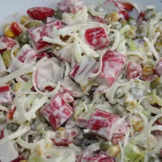 Pyszna sałatka z surimi, groszkiem, kukurydzą i warzywami, polana kremowym sosem. Idealna na każdą okazję, to najlepsza sałatka z surimi!