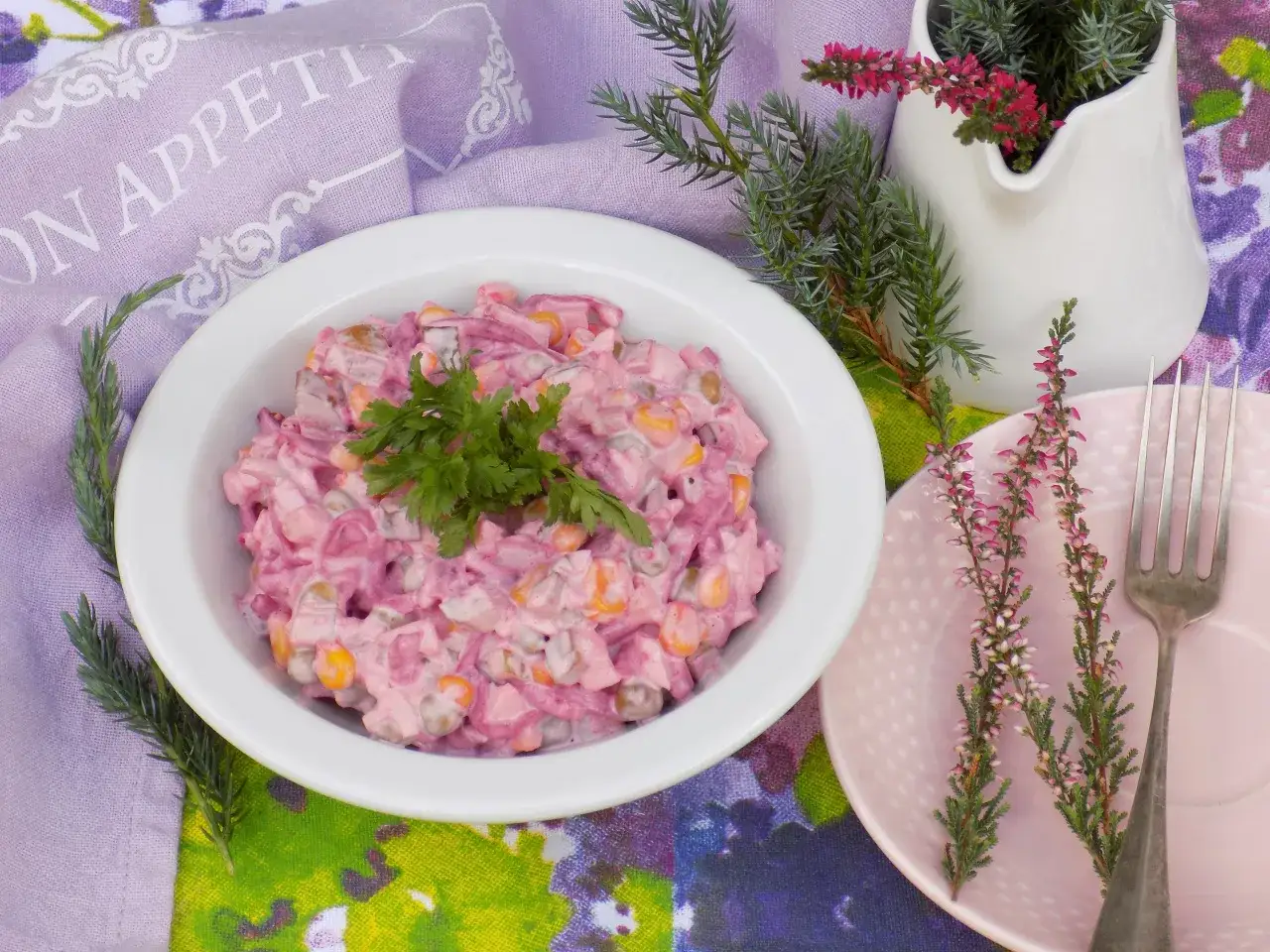 Pyszna sałatka z gotowanych buraków i jajek, udekorowana natką pietruszki, podana na talerzyku z wrzosem.