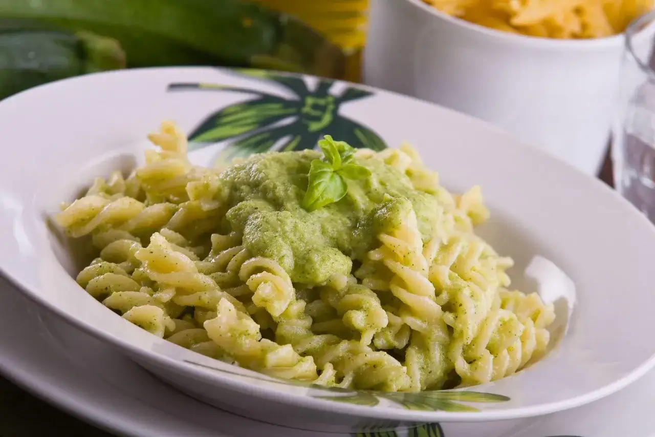 Pyszny makaron fusilli z kremowym sosem z cukinii, udekorowany listkiem bazylii. Idealny na szybki obiad.
