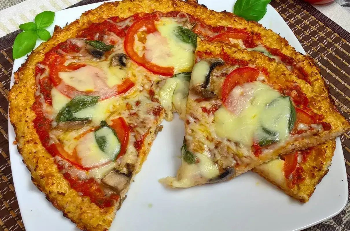 Pyszna pizza z kalafiora z pomidorami, mozzarellą i bazylią. Idealna dla tych, którzy szukają zdrowszej alternatywy.