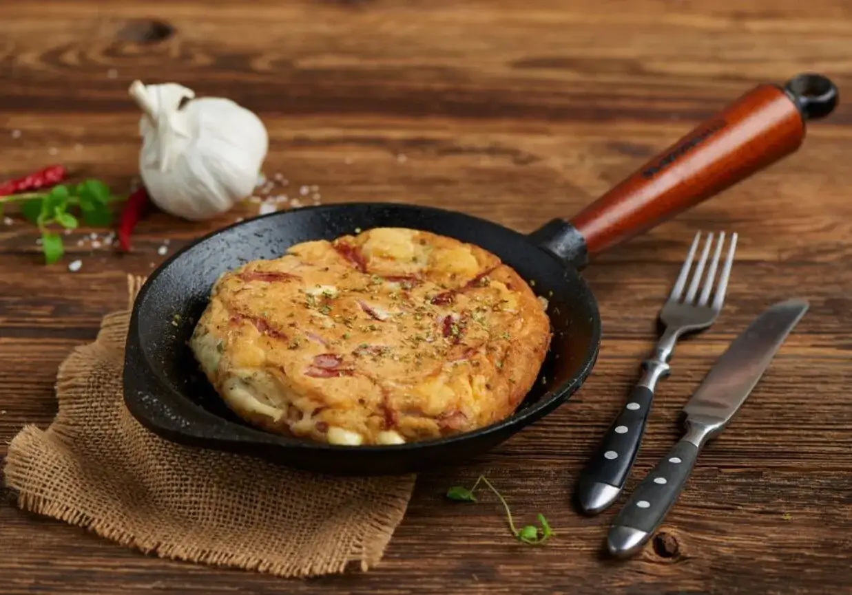 Gotowy omlet z szynką i serem na patelni, idealny na śniadanie. Prosty przepis, jak zrobić omlet z szynką i serem.