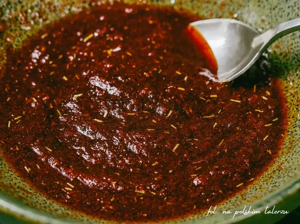 Gęsta, ciemna marynata do udek z kurczaka z ziołami, mieszana łyżką w misce. Idealna do pieczenia lub grillowania.
