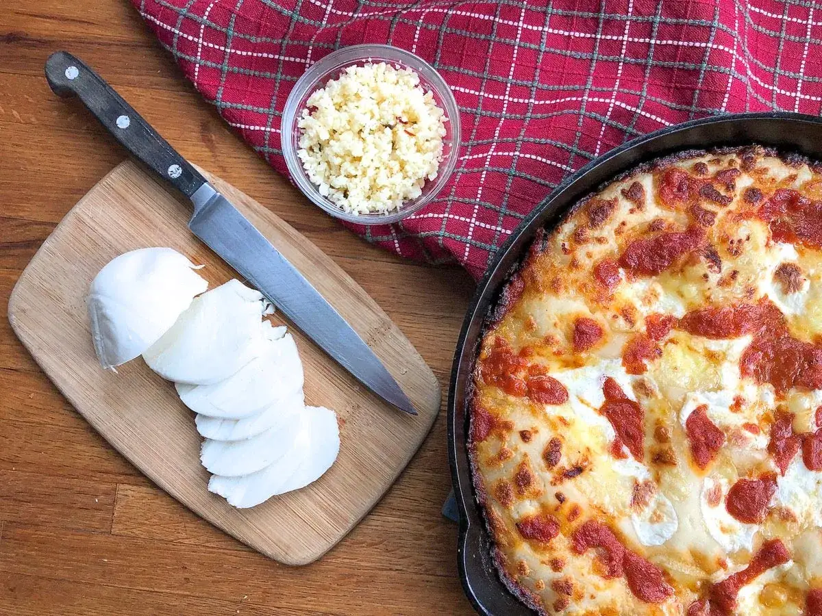 Gotowy ser do pizzy, pokrojona mozzarella i posiekany czosnek na desce. Idealny jaki ser do pizzy!