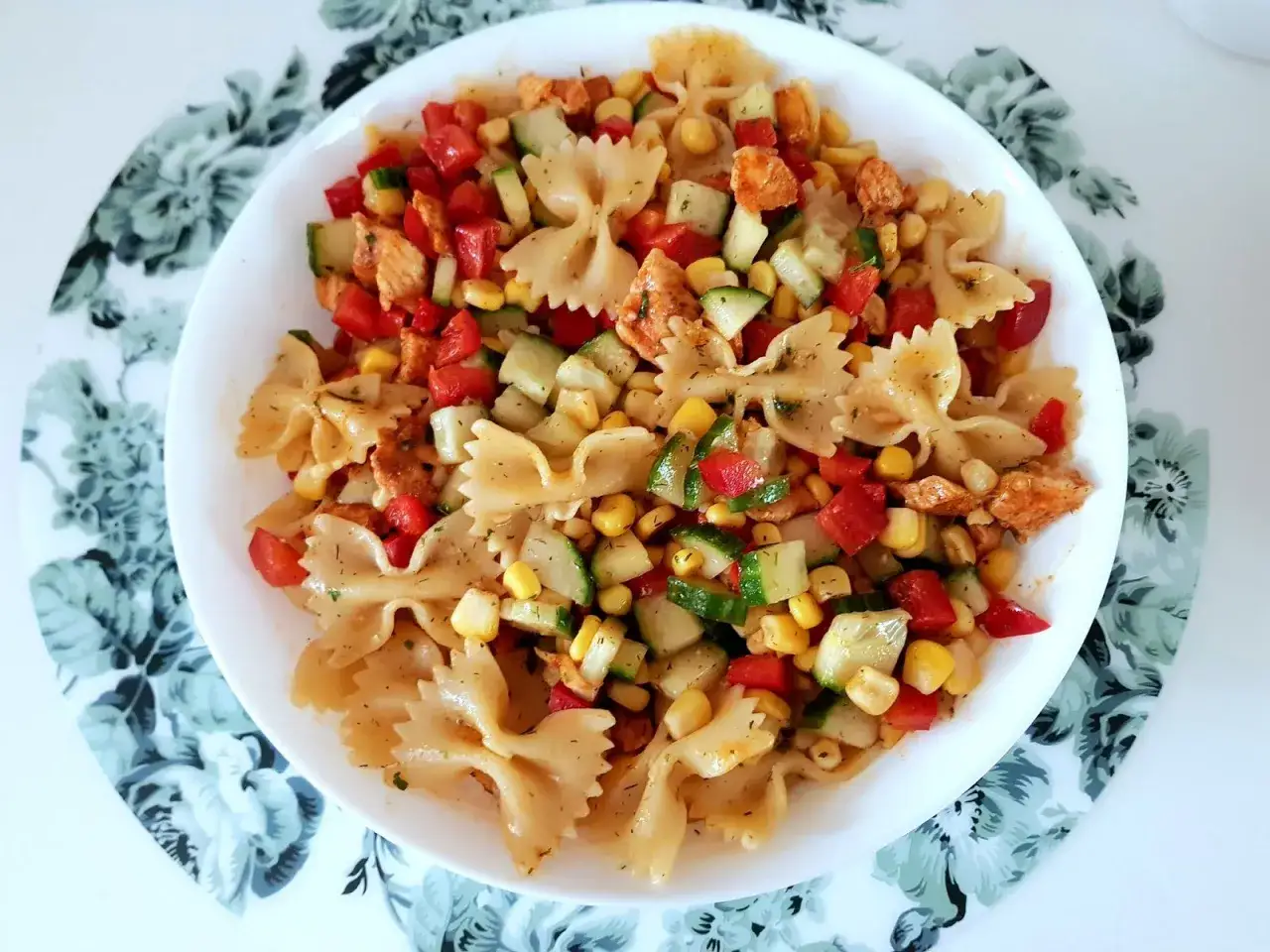 Pyszna, kolorowa sałatka z makaronem farfalle, kawałkami kurczaka, kukurydzą, pomidorkami i ogórkiem. Idealna na lato, to najlepsza sałatka z makaronem i kurczakiem!