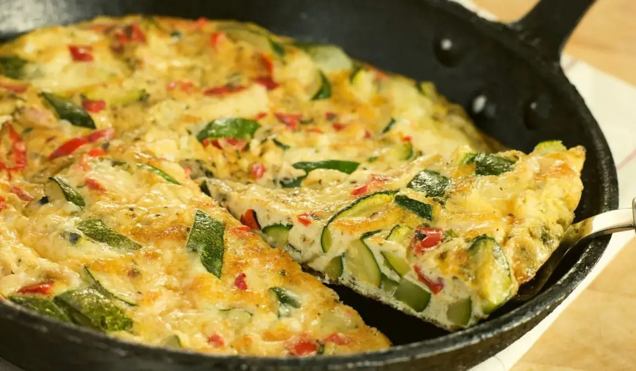 Pyszny omlet z cukinią i papryką, podany w żeliwnej patelni. Idealny na śniadanie lub lekki obiad.