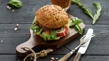 Pyszne domowe hamburgery z mięsa mielonego, podane na desce z ziołami i przyprawami. Idealne na letni wieczór.