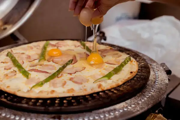Pizza z jajkiem - idealne żółtko i chrupiący spód. Jak to zrobić?